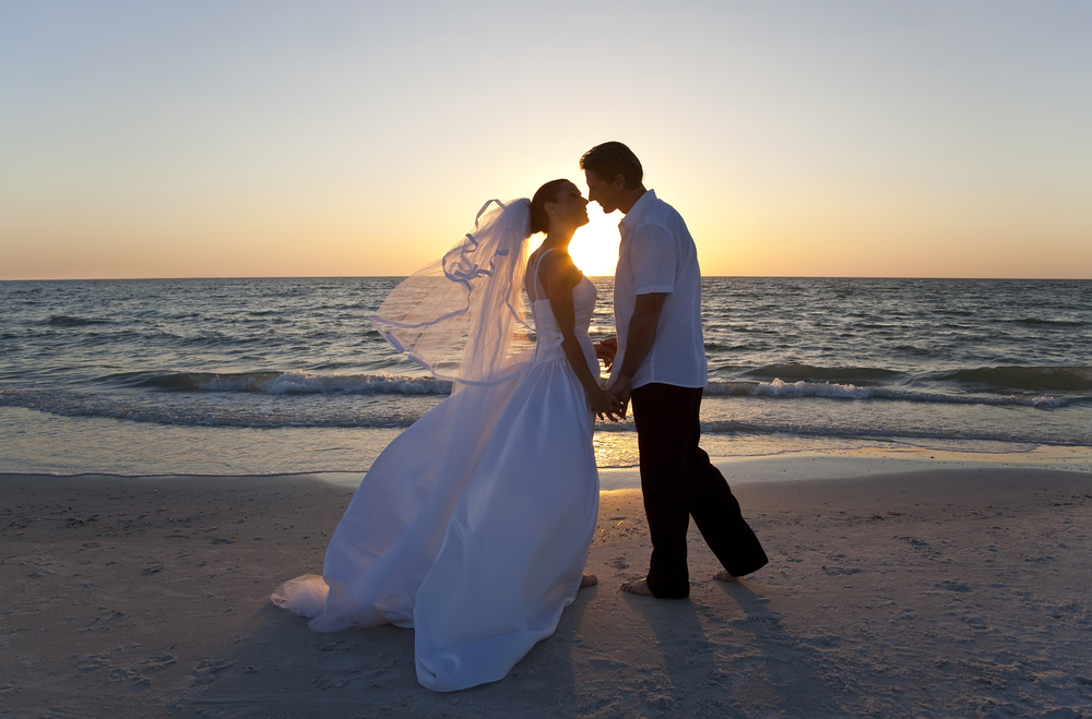 A,Married,Couple,,Bride,And,Groom,,Kissing,At,Sunset,On a beatiful tropical beach