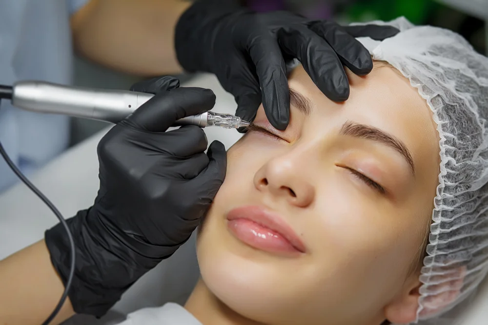 Permanent Eyeliner - The Ultimate Guide To A Beautiful, Effortless Look 1 Permanent eye make-up procedure, application to girls. Close up. Young beautiful woman doing permanent makeup in cosmetology salon. Girl applying permanent eyeliner in a beauty studio. Permanent Eyeliner - The Ultimate Guide To A Beautiful, Effortless Look / What Is Permanent Eyeliner? / Why Should You Consider Permanent Eyeliner? / The Permanent Eyeliner Procedure: What to Expect / Benefits of Permanent Eyeliner / Long-Lasting Results / Enhance Your Natural Beauty / How to Choose the Right Technician for Permanent Eyeliner / FAQs About Permanent Eyeliner / Ciao Bella Salon and Spa in Islamorada Florida