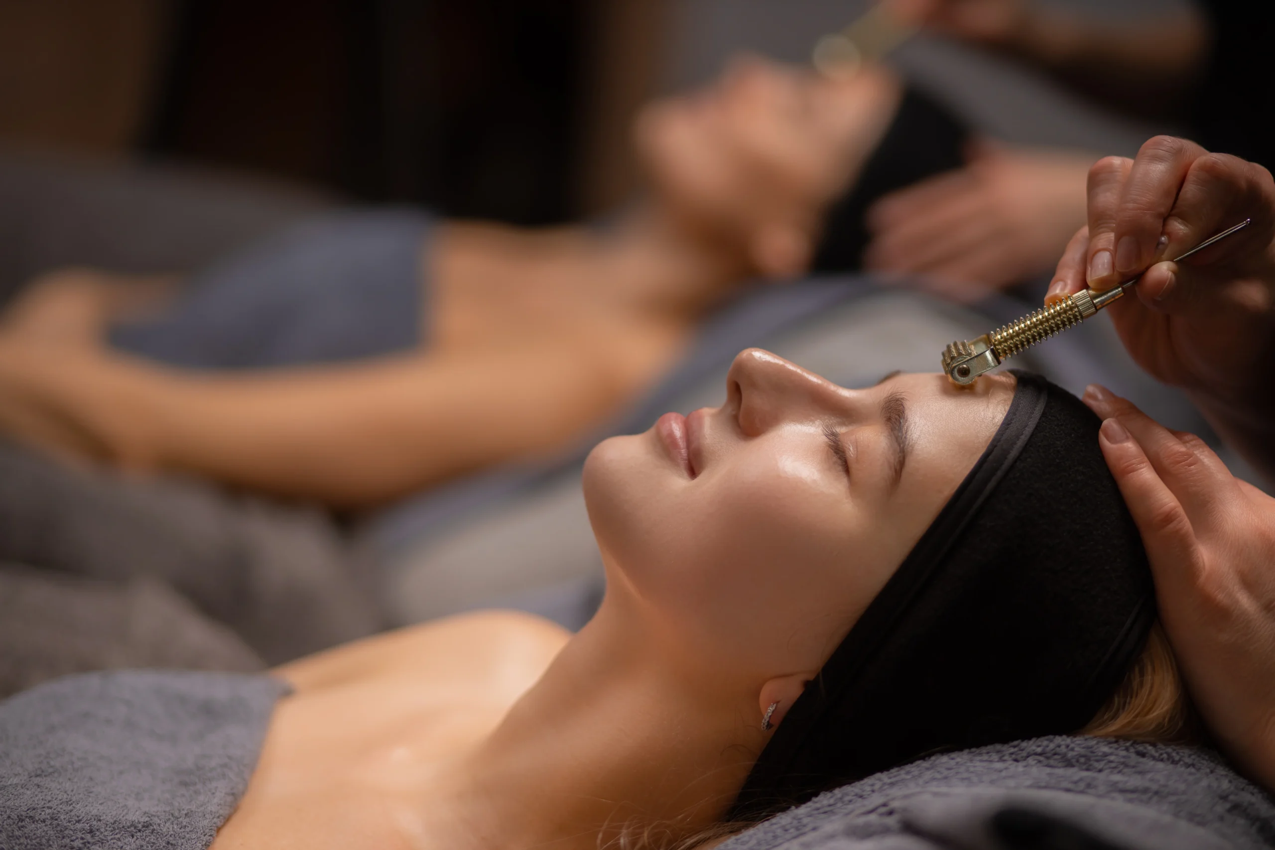 close-up photo of woman getting massage on forehead with the use of mesotherapy roller - Award-Winning Spa Treatments in Islamorada: Relax & Rejuvenate at Ciao Bella