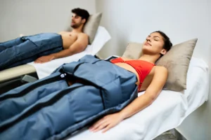 Young couple receiving pressotherapy at health spa. - Unlock the Benefits of Compression Therapy: Enhance Your Recovery and Wellness Journey in the Florida Keys - Ciao Bella Salon Spa