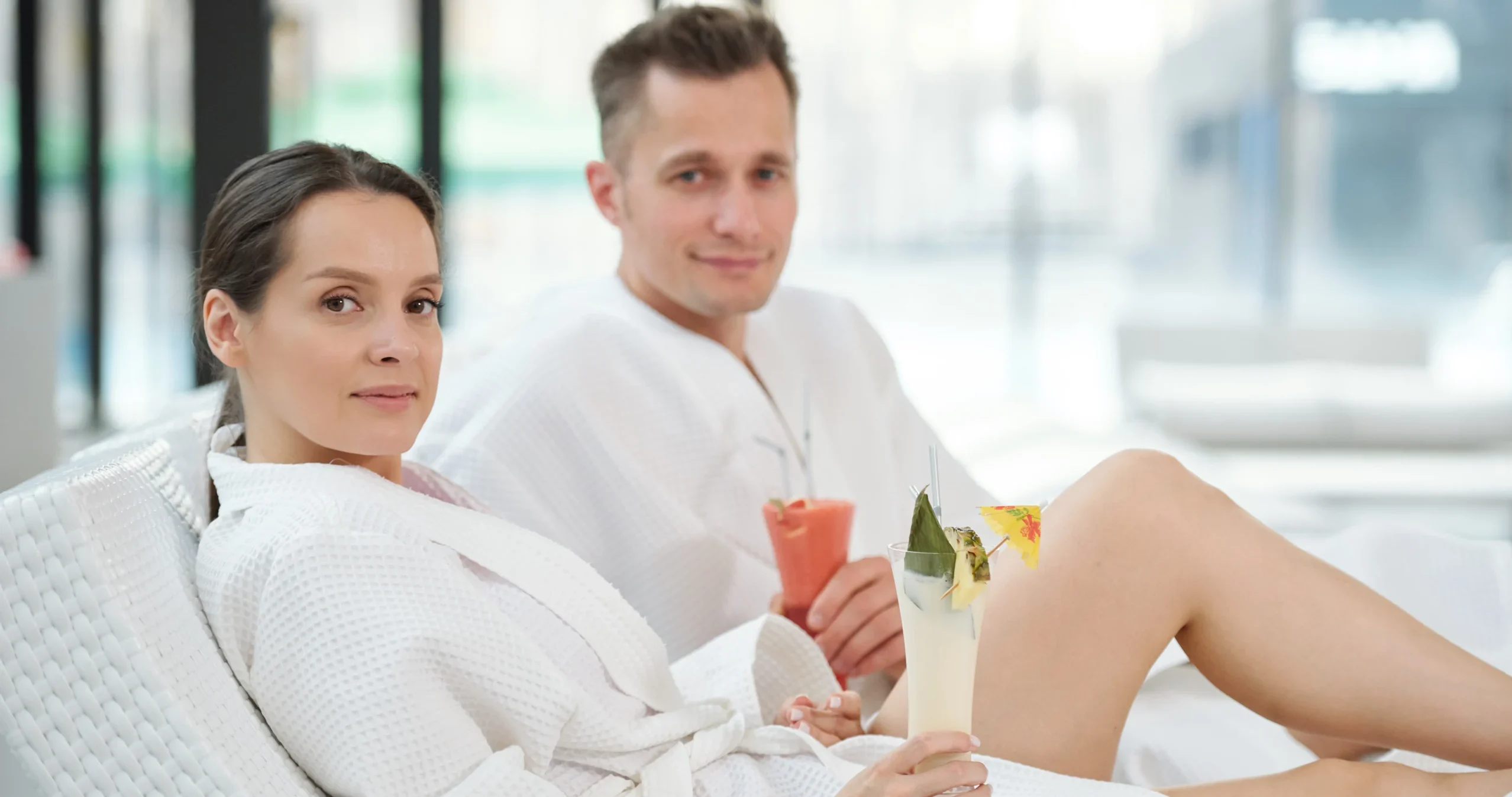 Young couple in bathrobes relaxing in spa center and having tropical cocktails - Unwrap Romance in Islamorada: A Holiday Spa Day for Two at Ciao Bella - Unwrap Romance in Islamorada: A Holiday Spa Day for Two at Ciao Bella - Ciao Bella Salon Spa Islamorada