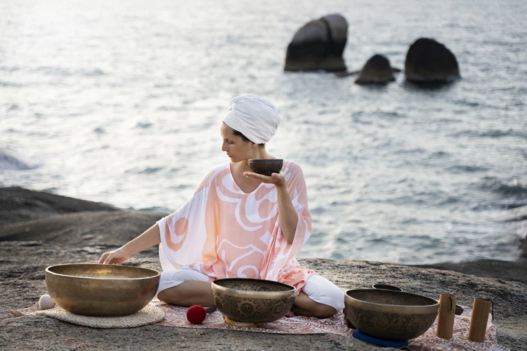 full shot woman with singing bowls beach scaled - Spring Renewal in Islamorada: Refresh Your Body and Mind with Ciao Bella’s Spa Services