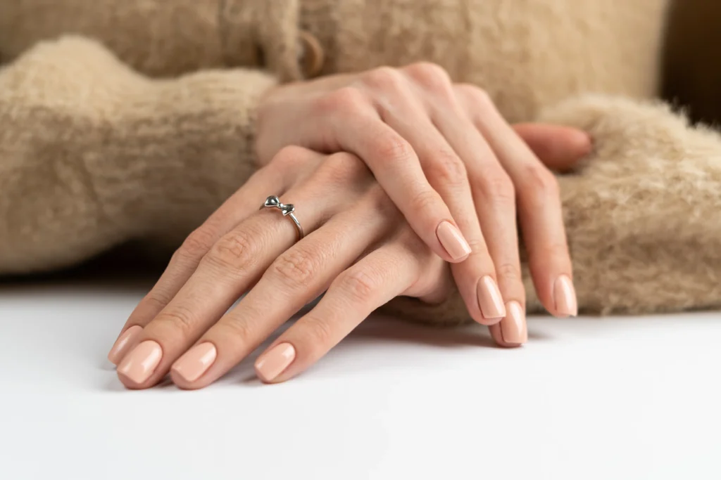 2026 Nail Trends: Elegant and Expressive Looks for Every Occasion 3 graceful thin fingers girl with trendy pastel nude manicure fluffy soft sweater cute silver ring bow - 2026 Nail Trends: Elegant and Expressive Looks for Every Occasion - Ciao Bella Salon Spa