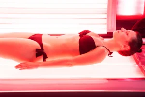 woman relaxing in tanning bed red light therapy - The Longevity Gift: Why Red Light Therapy is the Ultimate Mother’s Day Self-Care - Ciao Bella Islamorada Salon Spa