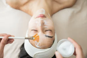 woman receiving a facial treatment at a spa - Revitalize Your Skin with a Custom Facial: The Perfect Treatment After a Day in the Florida Keys Sun - Ciao Bella Islamorada