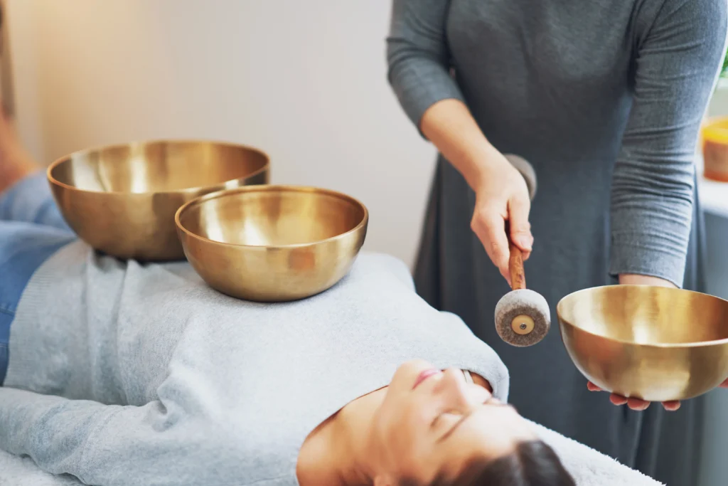 The Science of Sound: How a Sound Healing Session Resets Your Nervous System 2 woman having a tibetan sound bowl - The Science of Sound: How a Sound Healing Session Resets Your Nervous System - Ciao Bella Islamorada